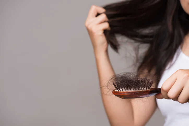 Healthy concept. Woman show her brush with long loss hair and looking at her hair.